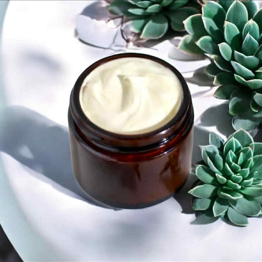 Jar of cream with succulents on a white surface